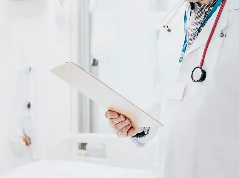 Doctor with stethoscope holding patient list, symbolizing guidance and oversight