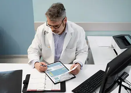Doctor at a table, reviewing patient documents