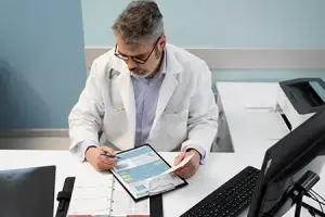 Doctor at a table, reviewing patient documents